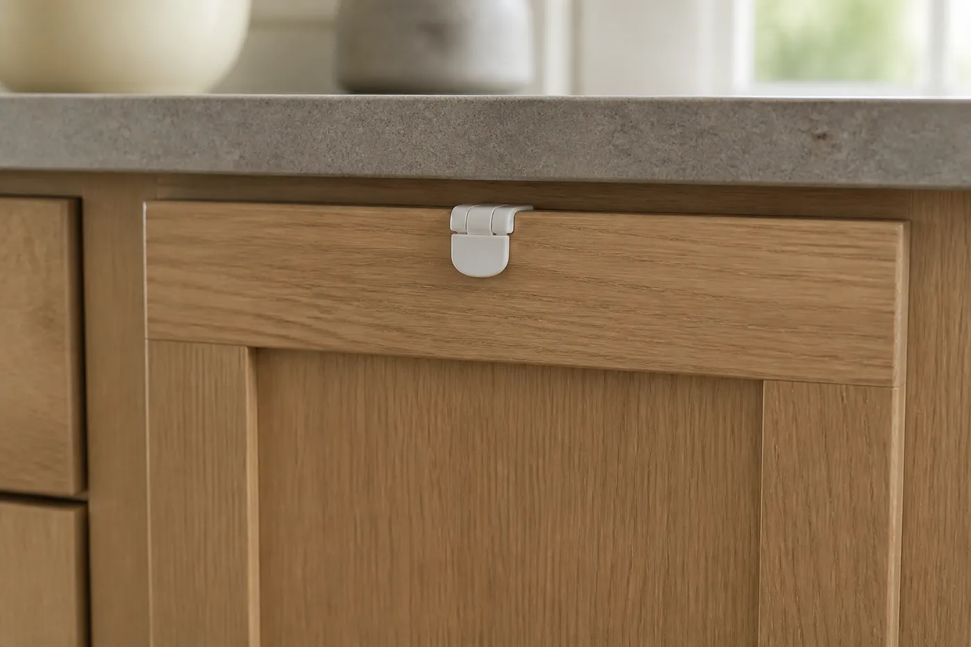 A closed kitchen drawer with a childproof catch fitted to its front