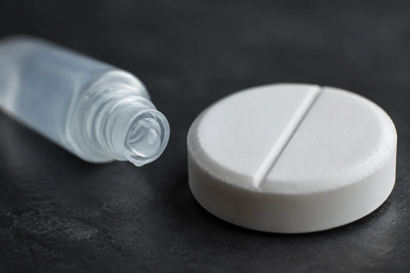 A small tube of veterinary ear gel beside a human tablet for scale