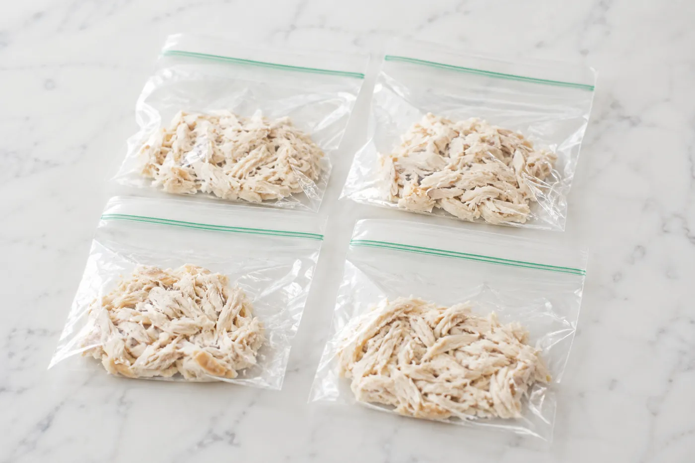 Shredded cooked chicken portioned flat in small freezer bags