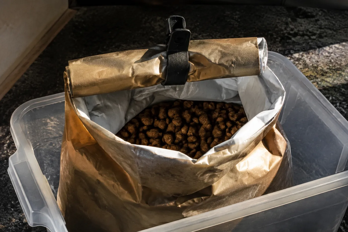 An opened food bag rolled and clipped inside a storage container